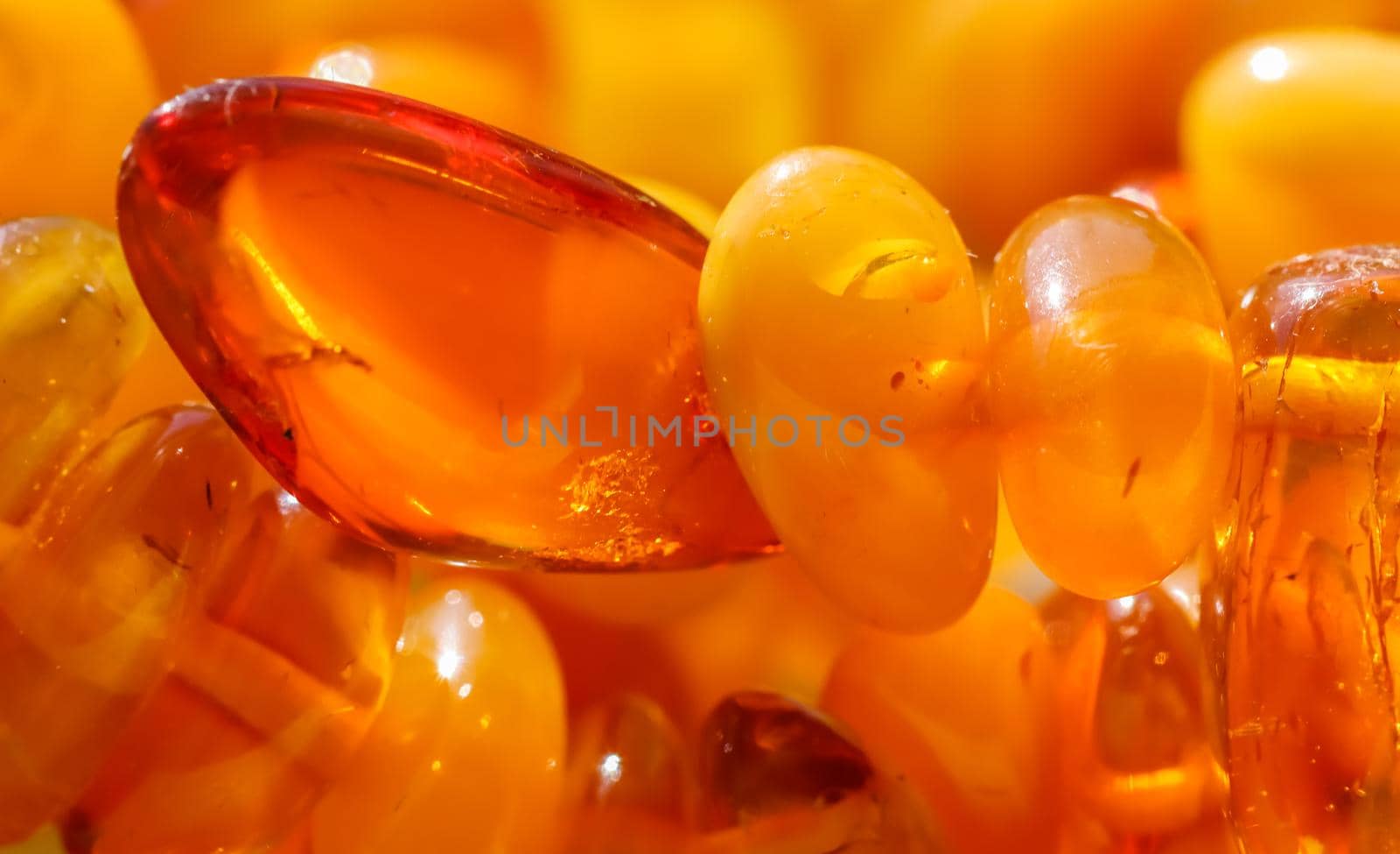 Sunny beads of fire amber. Natural gemstone background, jewelry concept by Olayola