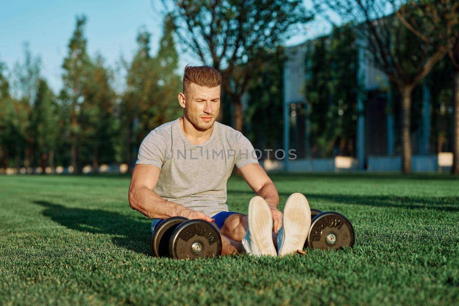 athletic man with dumbbells in the park exercise motivation by Vichizh