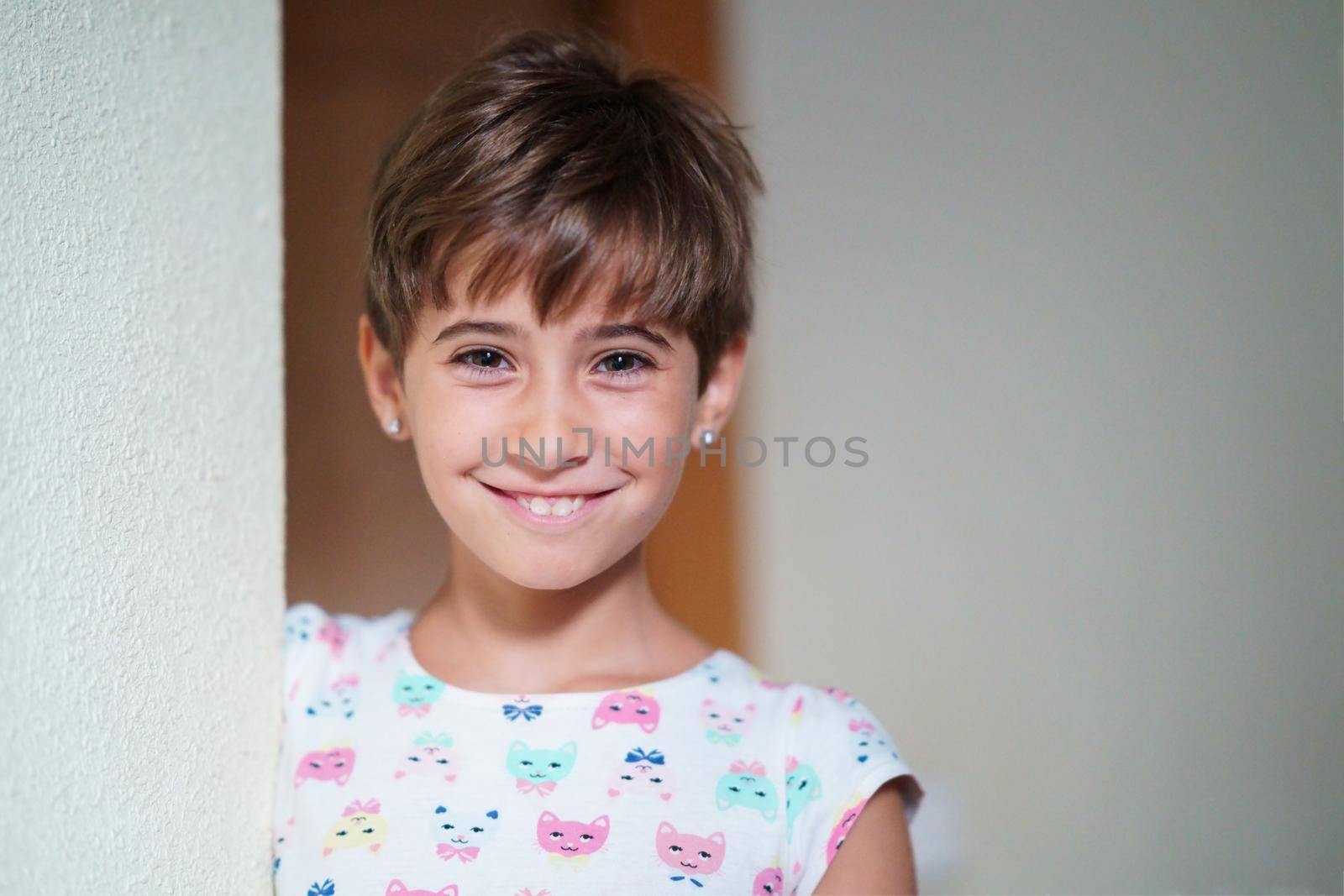 Funny little girl, eight years old, staring to camera smiling at home