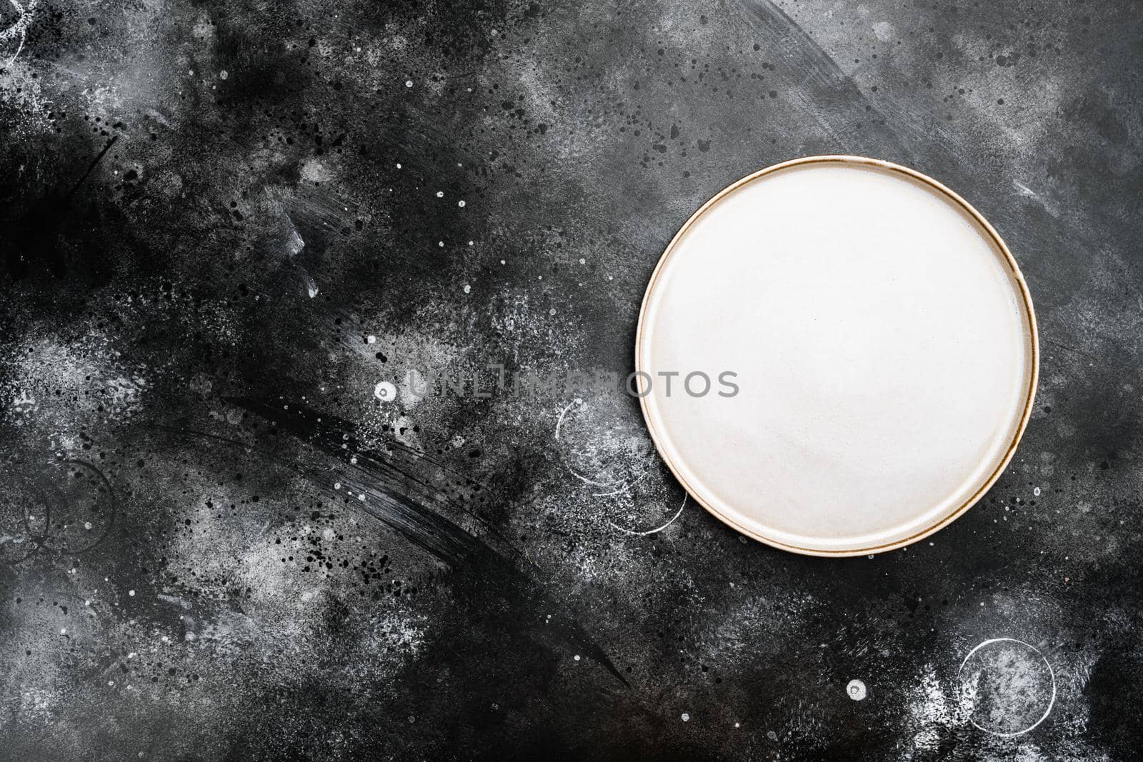Porcelain empty white plate set with copy space for text or food with copy space for text or food, top view flat lay, on black dark stone table background