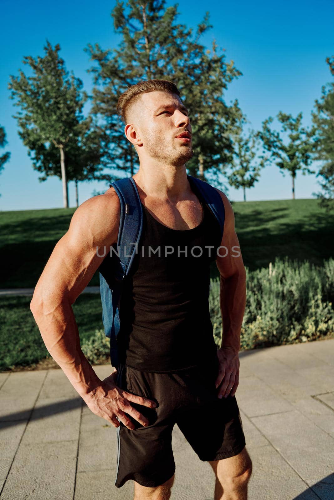 athletic man with dumbbells in his hands in the park training lifestyle by Vichizh