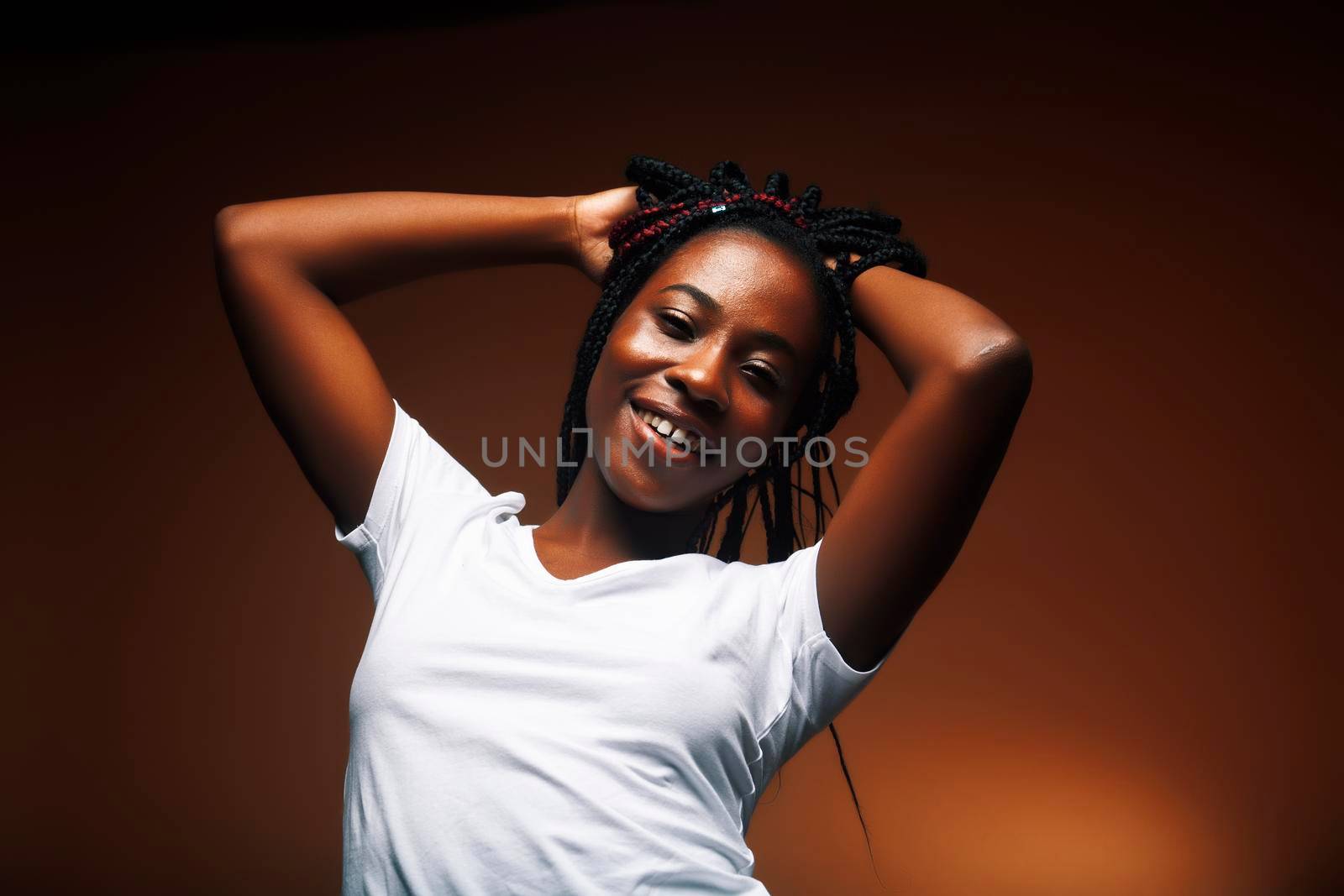 pretty young african american woman posing cheerful gesturing on brown background, lifestyle people concept by JordanJ