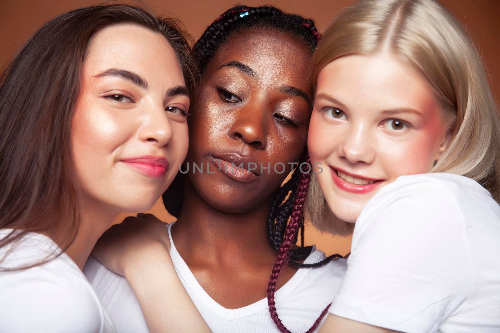 young pretty asian, caucasian, afro woman posing cheerful together on brown background, lifestyle diverse nationality people concept by JordanJ