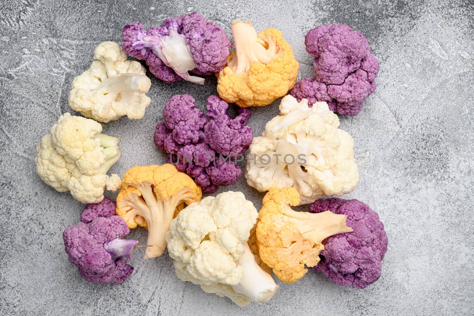 Purple yellow and white cauliflower set, on gray stone table background, top view flat lay