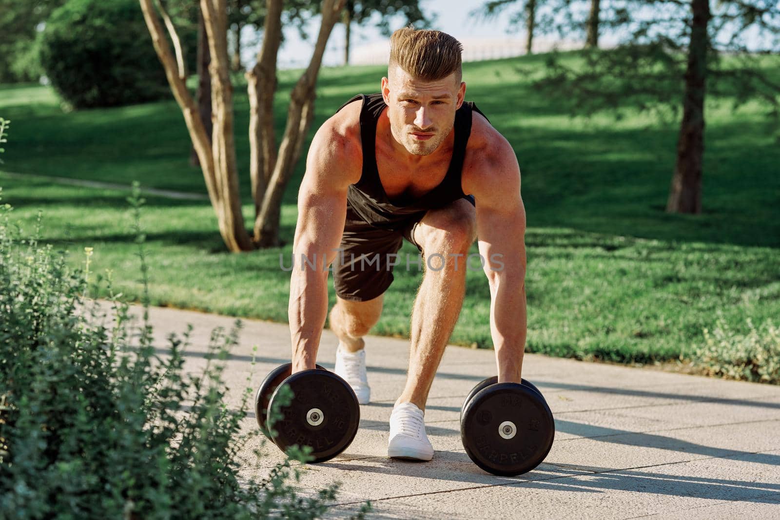 athletic man with dumbbells workout outdoors motivation. High quality photo