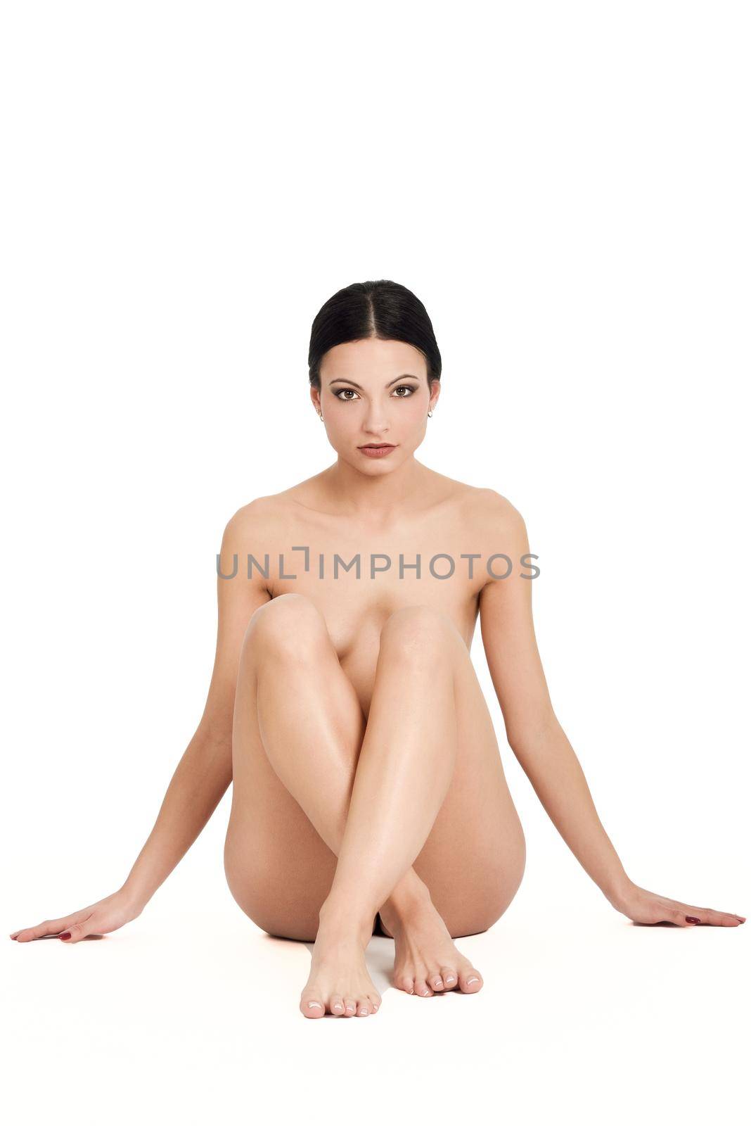 Young naked brunette woman sitting on white background. Perfect epilated skin