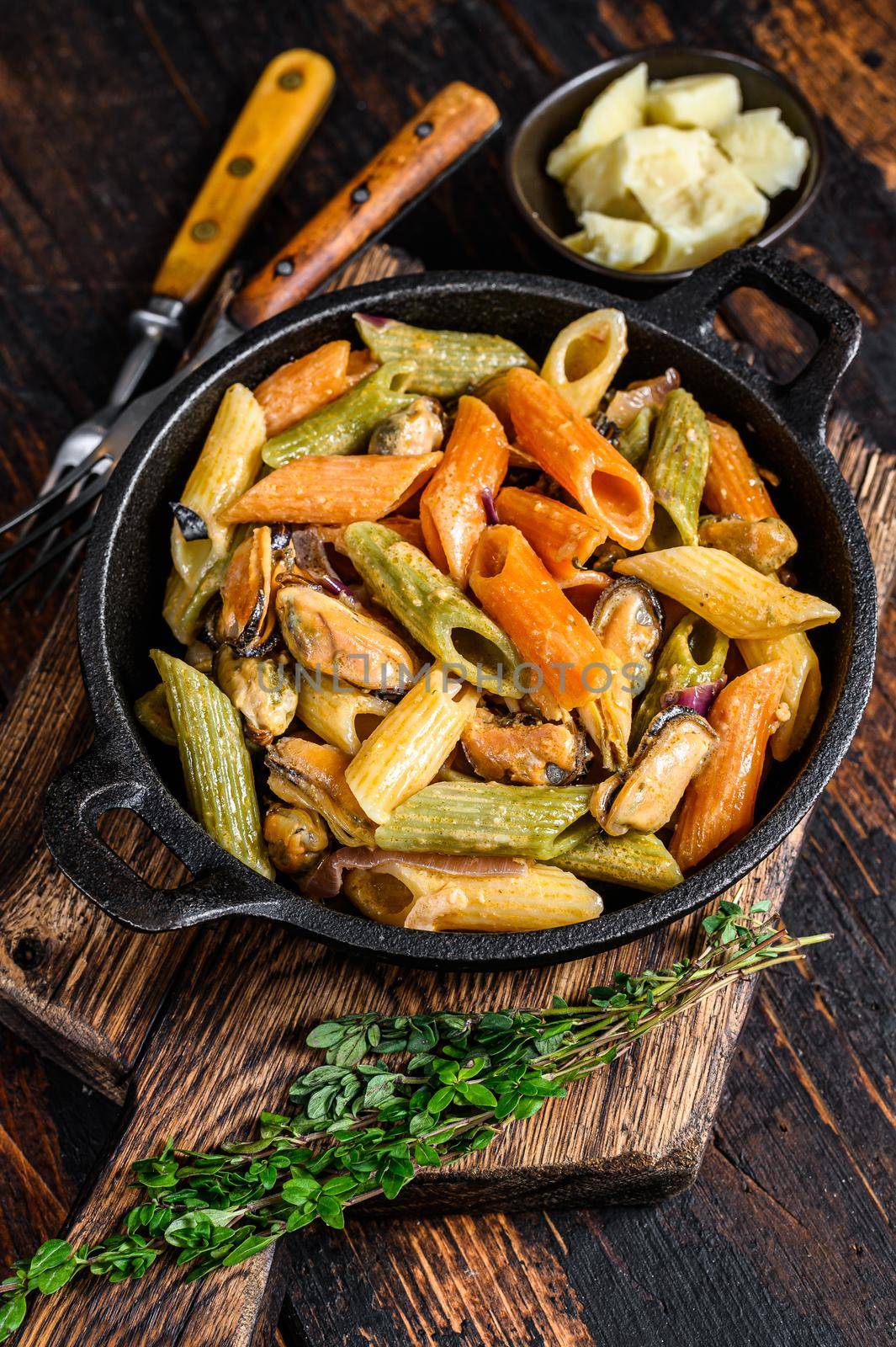 Penne pasta in cream sauce with seafood. Dark Wooden background. Top view.