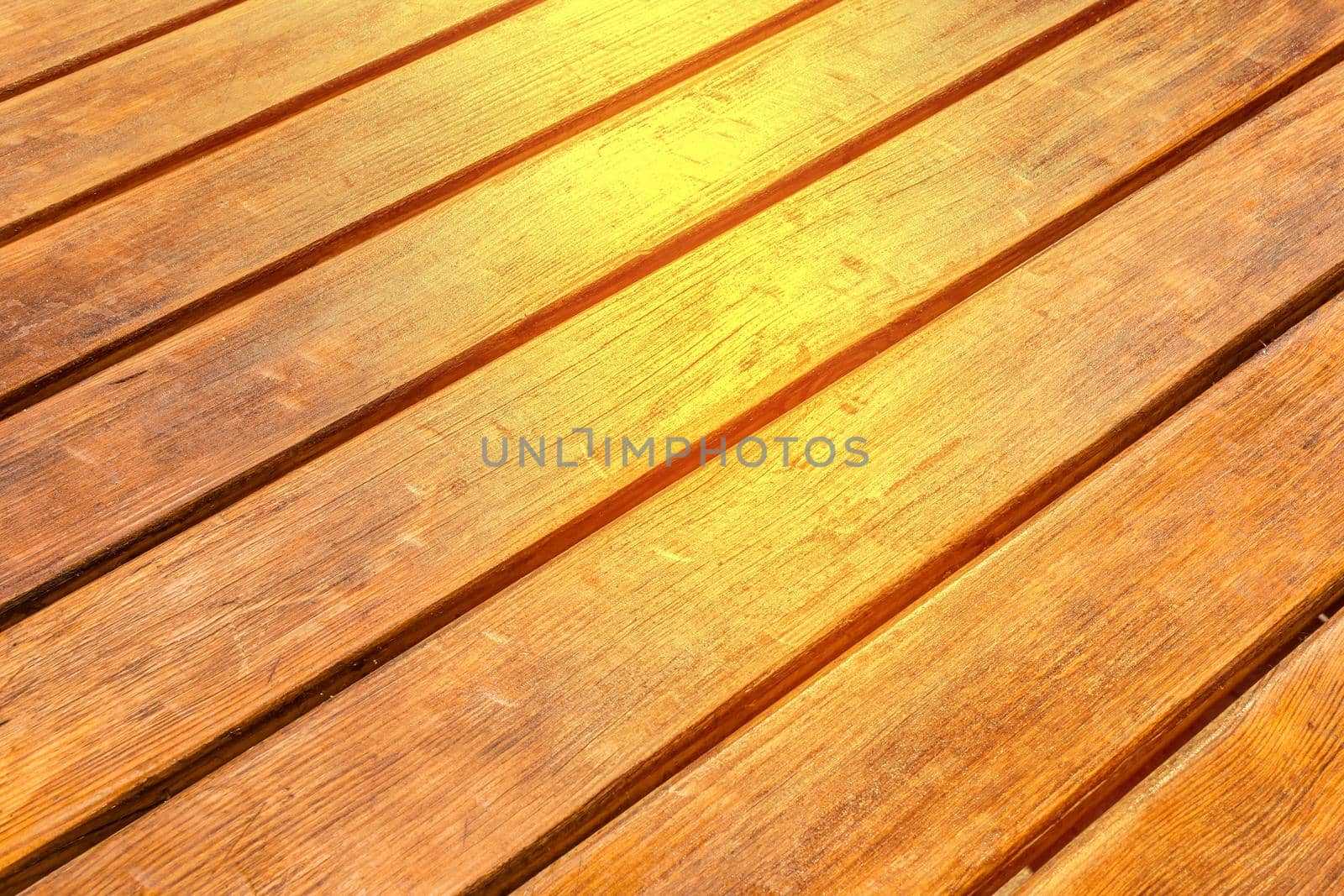 Diagonal wood surface texture with sunlight brown planks table background.