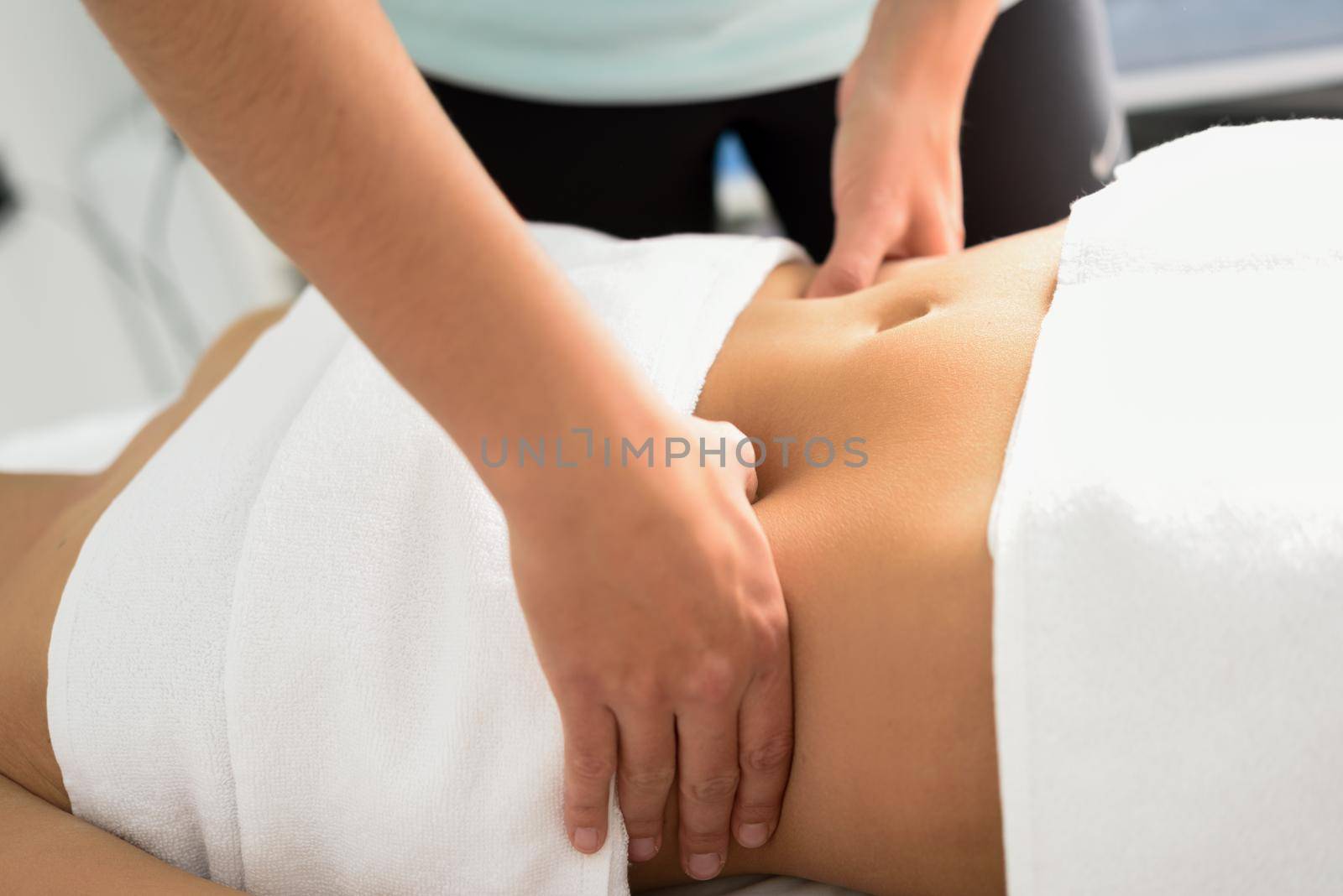 Hands massaging female abdomen.Therapist applying pressure on belly. by javiindy