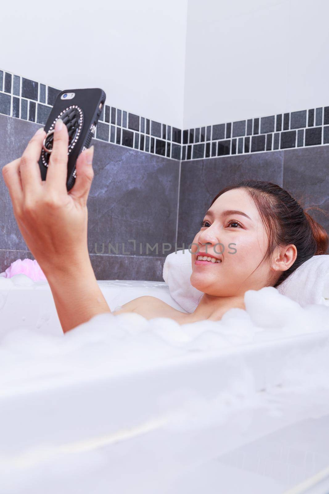 woman making selfie photo in bathtub in bathroom by geargodz