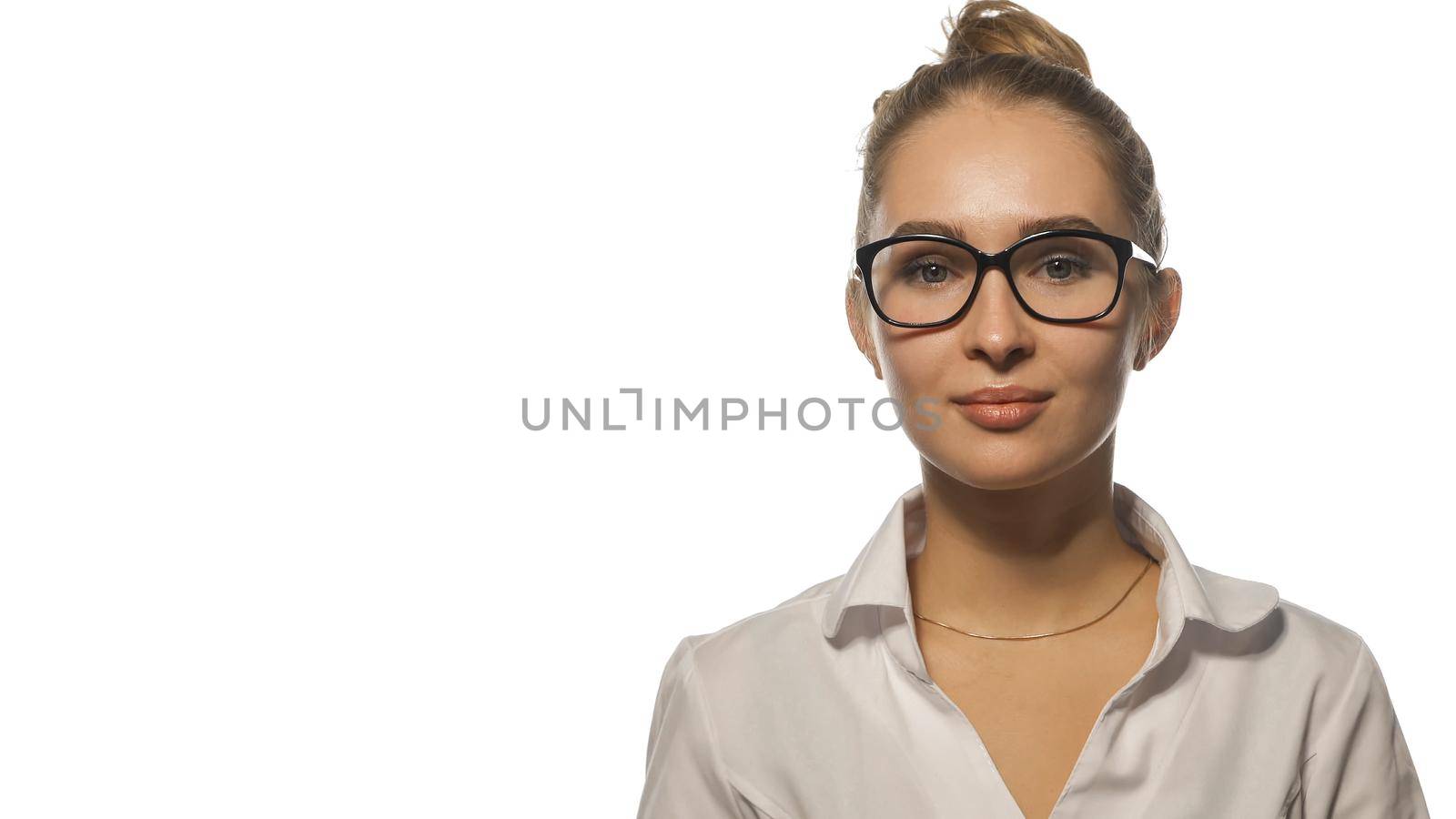 Beautiful nurse in eye glasses looking at the camera wearing white medical uniform isolated on white background.