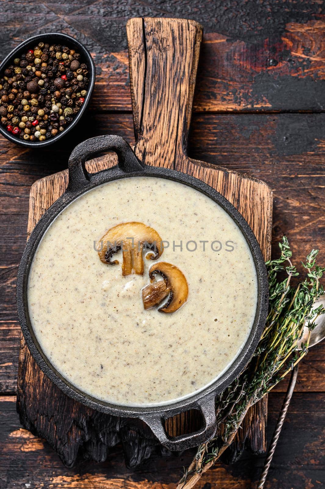 Mushroom cream soup with herbs and spices. Dark Wooden background. Top view.