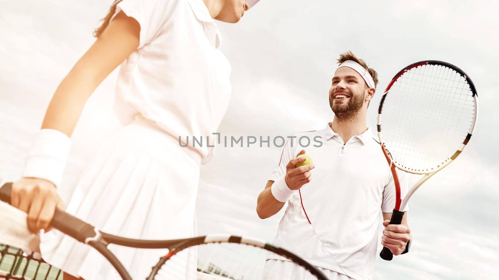 They play like a team. Cropped shot of beautiful young woman and man holding tennis rackets and discussing set