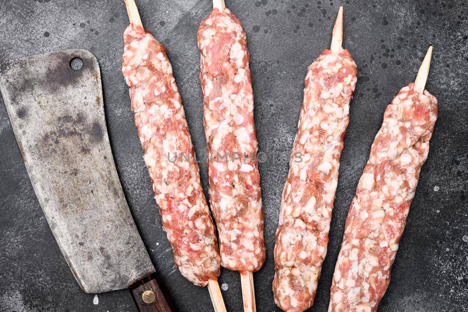 Minced and shaped lamb mutton kebabs set, on black dark stone table background, top view flat lay