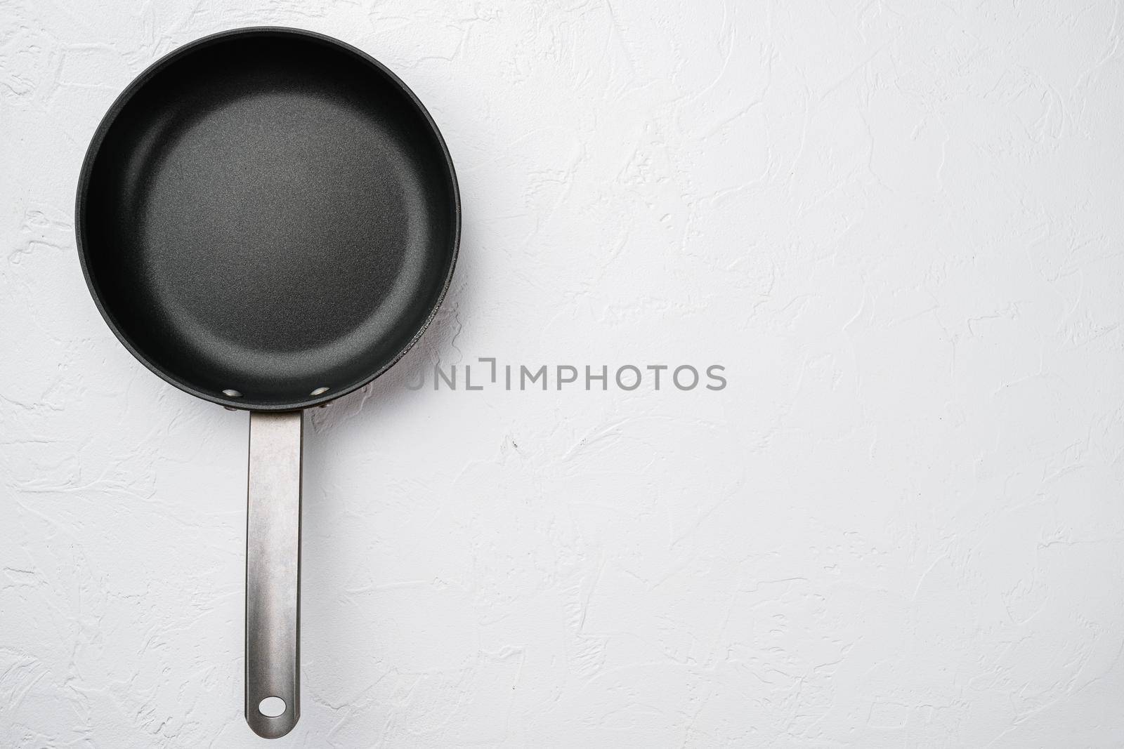 Empty skillet, frying pan set with copy space for text or food with copy space for text or food, top view flat lay, on white stone table background