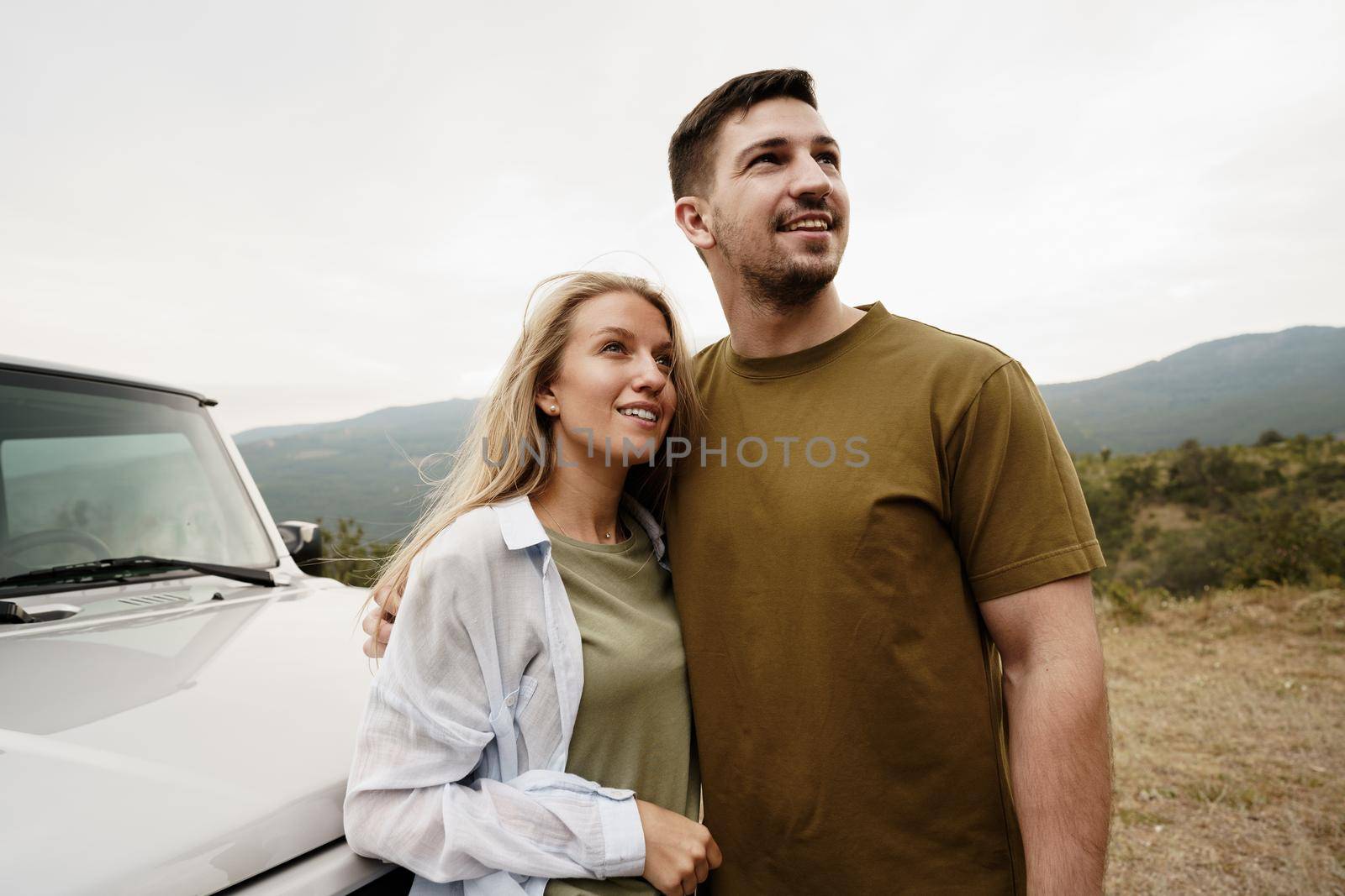 Young couple is on romantic trip to the mountains by car by Fabrikasimf
