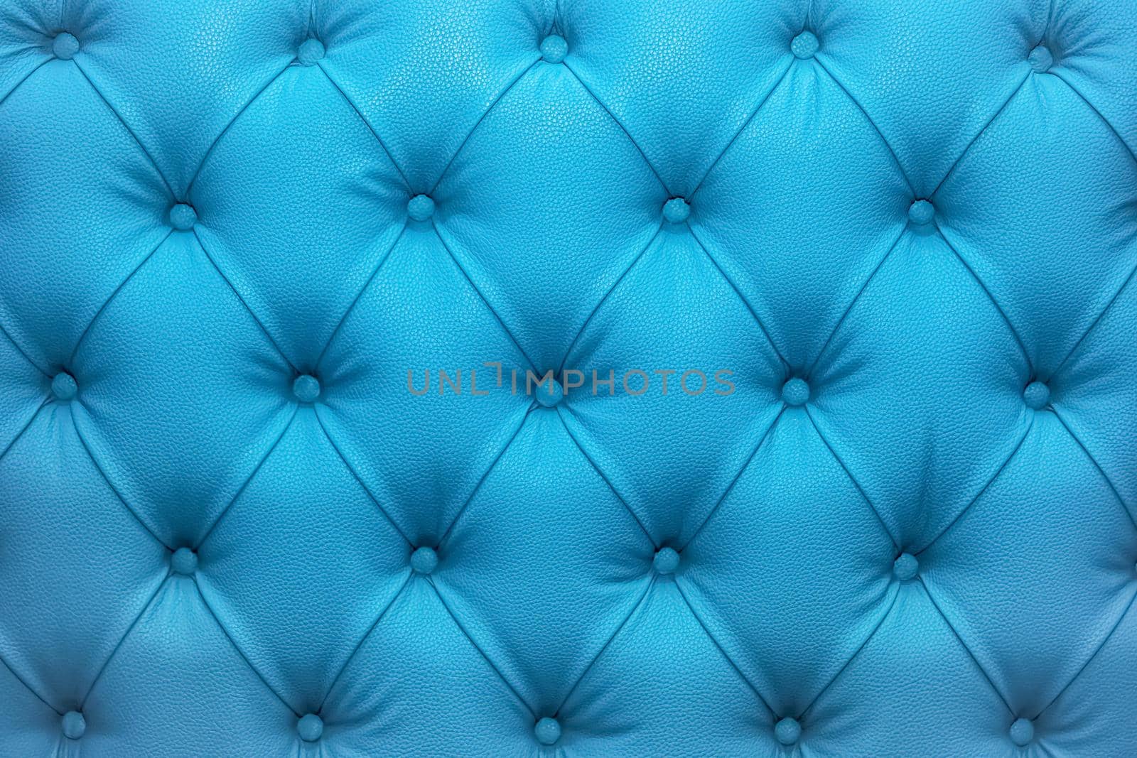 Blue natural leather sofa upholstery texture background.