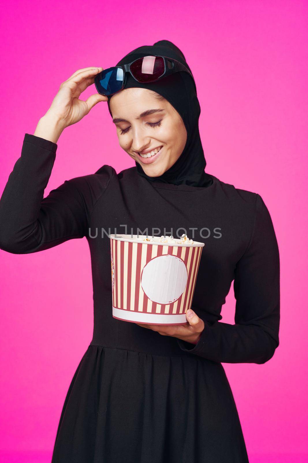 Muslim woman in 3D glasses popcorn entertainment movies isolated background. High quality photo