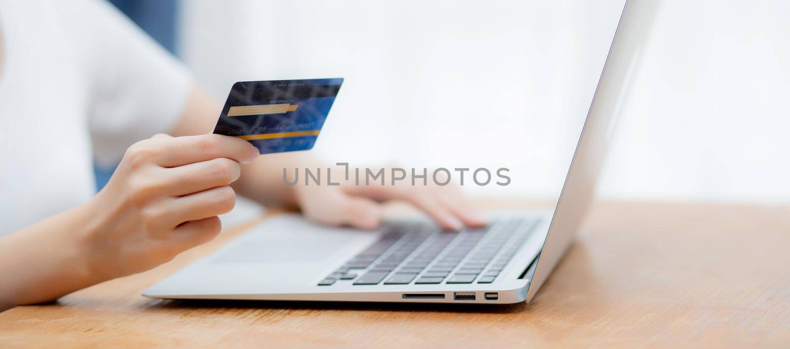 Hand of young woman holding credit card buying shopping online with laptop computer, girl purchase and payment on internet, commerce and e-business, transaction for finance, business concept.