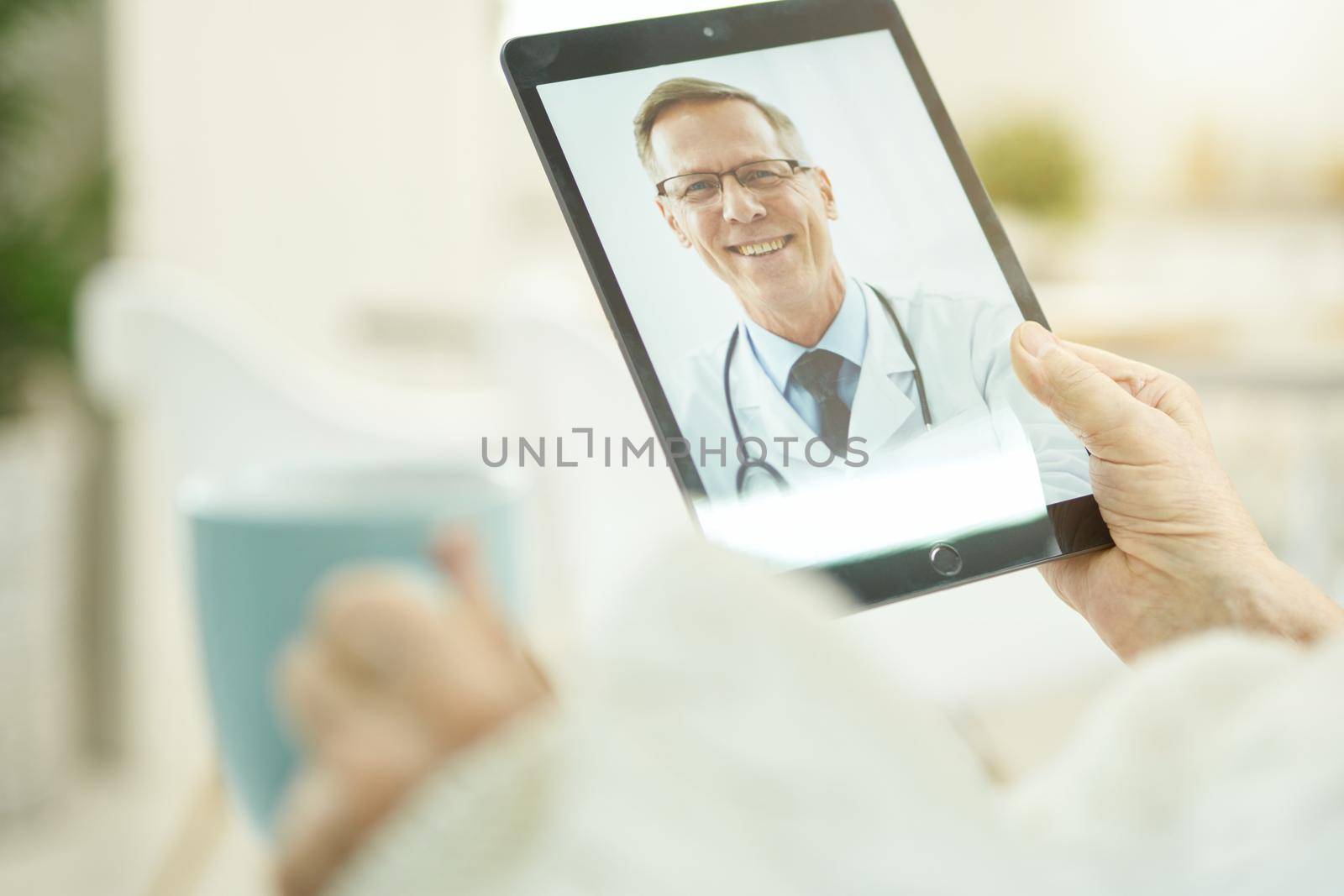 Cropped photo of senior person consulting medical specialsit via internet with a help of a tablet