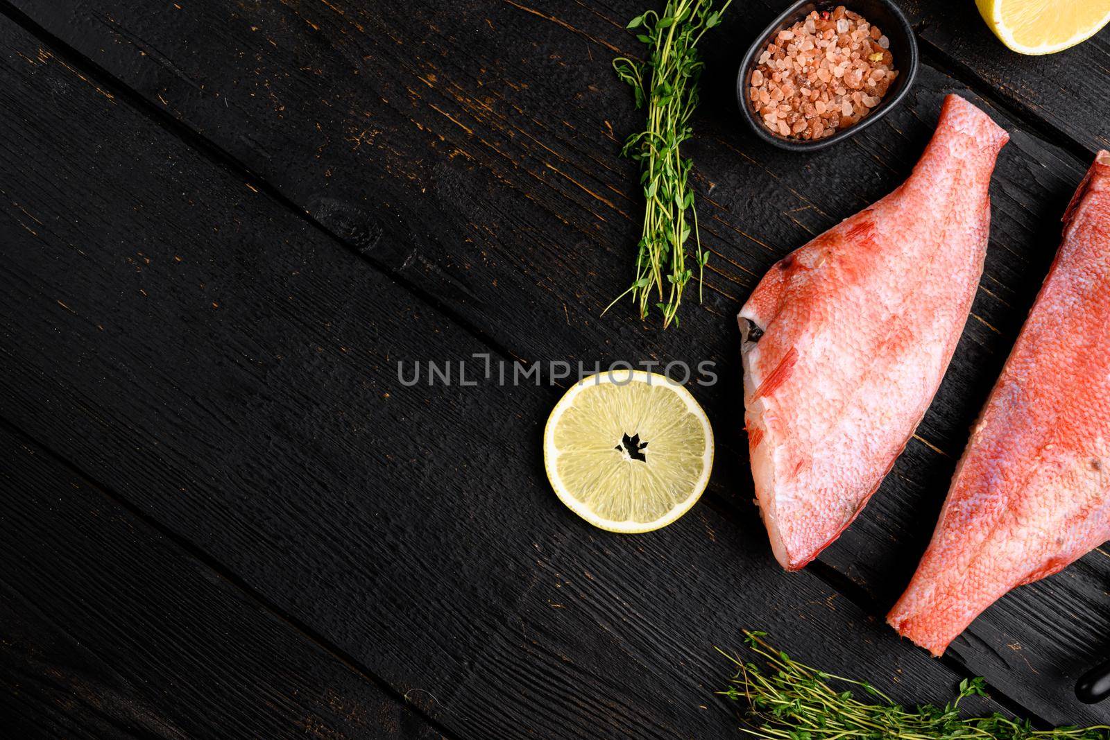 Raw fish perch without a head set, on black wooden table background, top view flat lay, with copy space for text