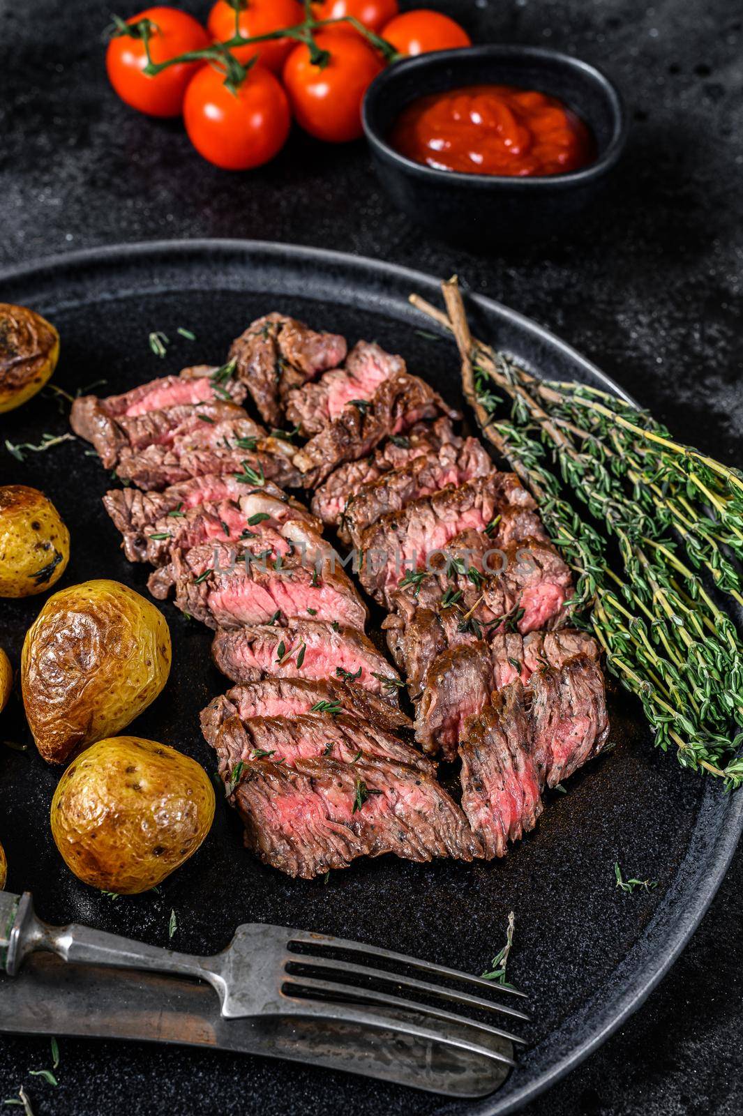 Flank grilled meat beef Steak with fried potato. Black background. Top view.