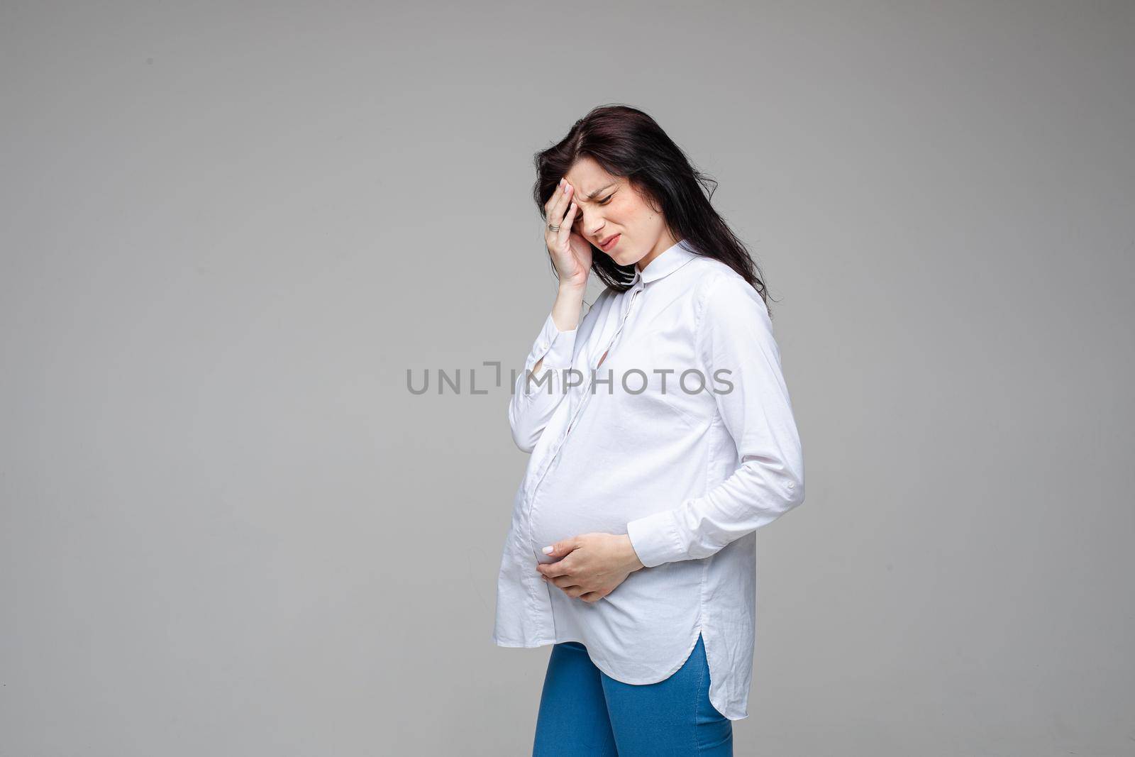 pregnant woman has a headache in the studio by StudioLucky