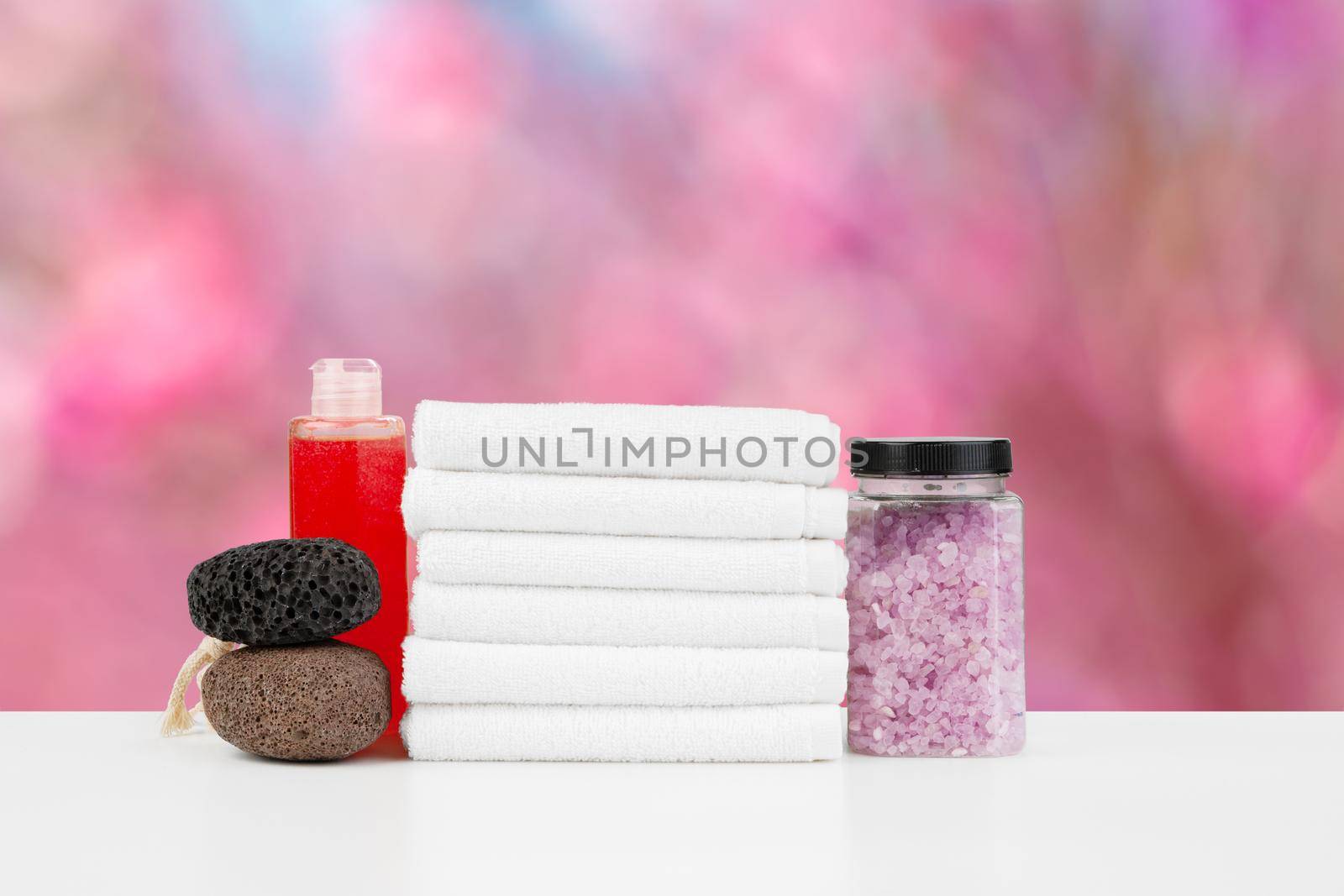 Various spa beauty threatment products and towels against blurred background, front view