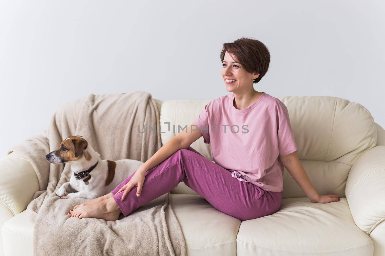 Young attractive woman dressed in beautiful colorful pajama posing as a model in her living room. Comfortable sleepwear, home relaxation and female fashion concept