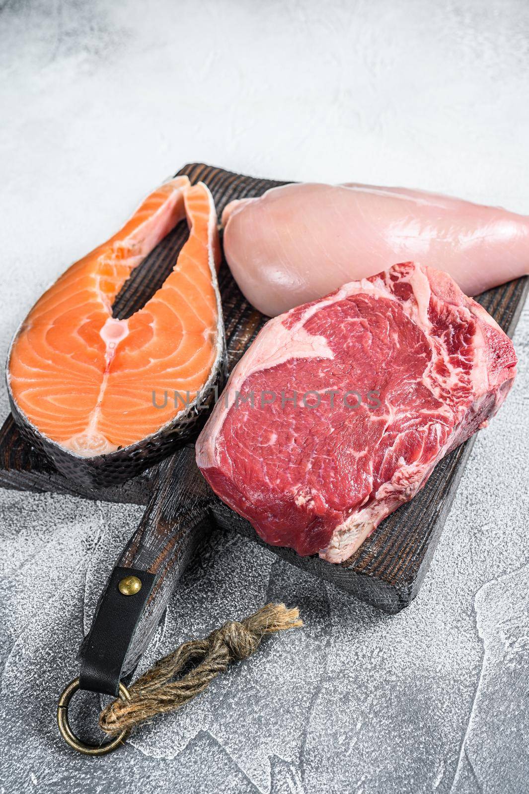 Set of raw meat steaks salmon, beef and chicken. White background. Top view by Composter