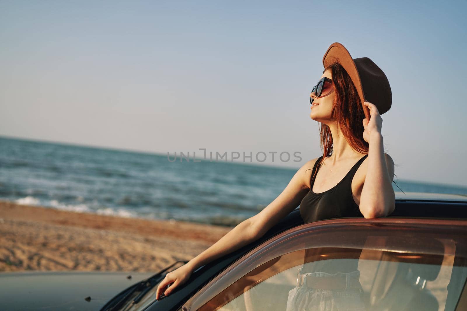 pretty woman in sunglasses near the car on the beach travel lifestyle. High quality photo