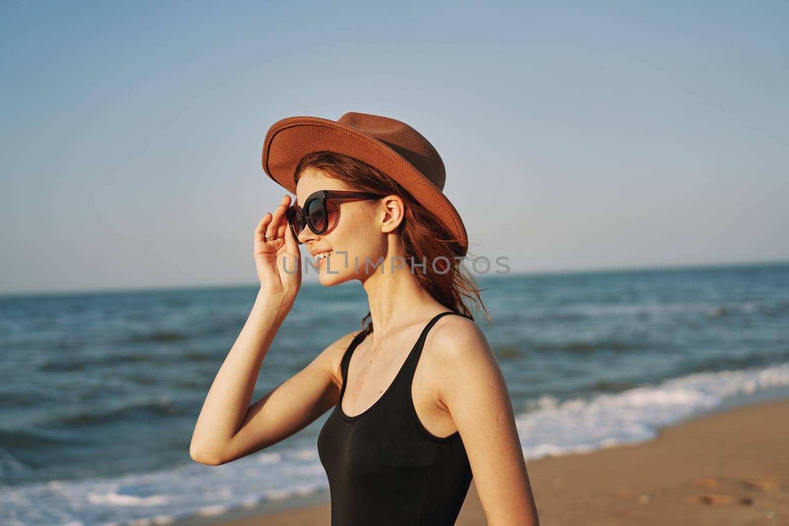 woman in a hat sunglasses by the ocean travel sun. High quality photo