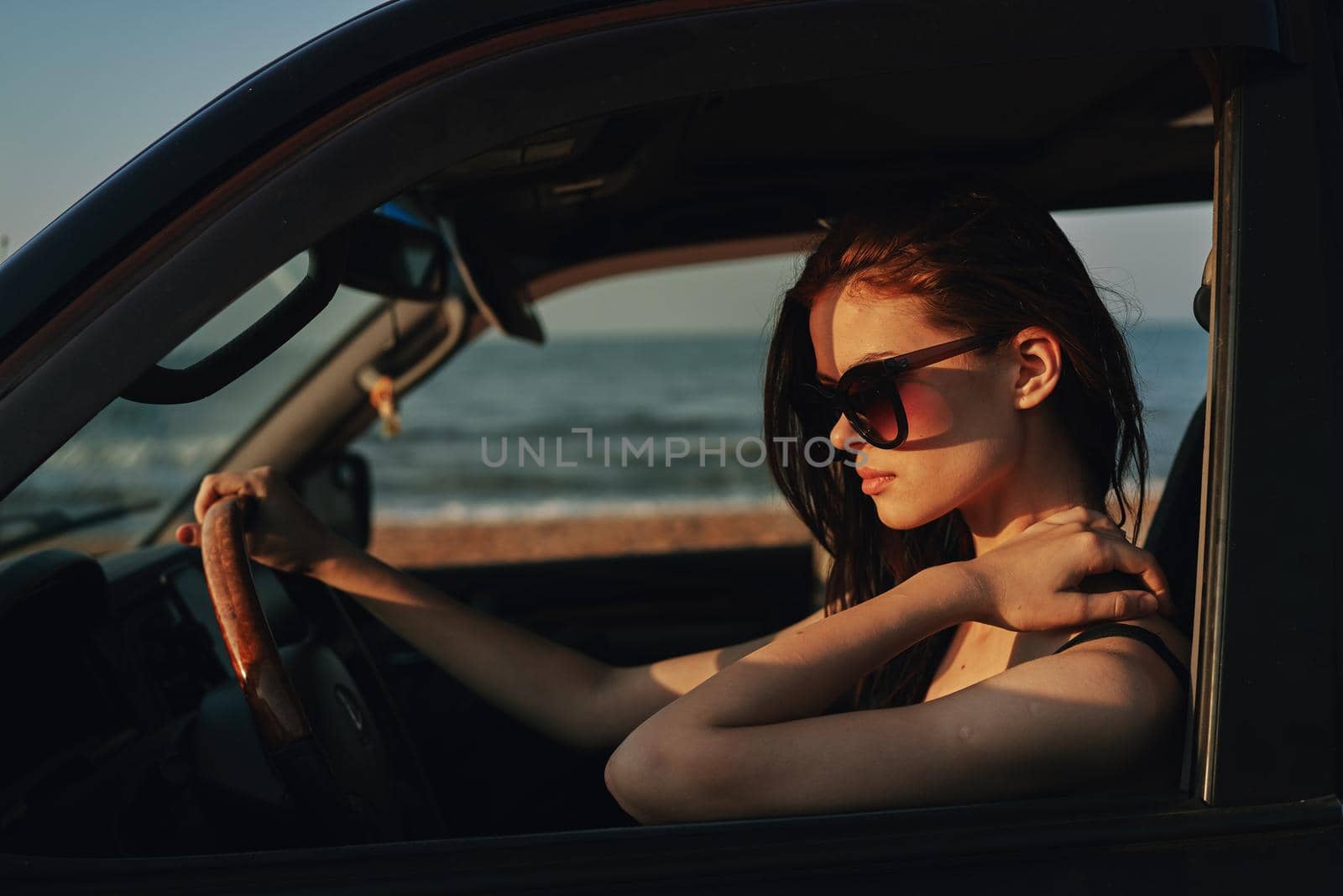woman on the beach is with a car wearing sunglasses travel. High quality photo