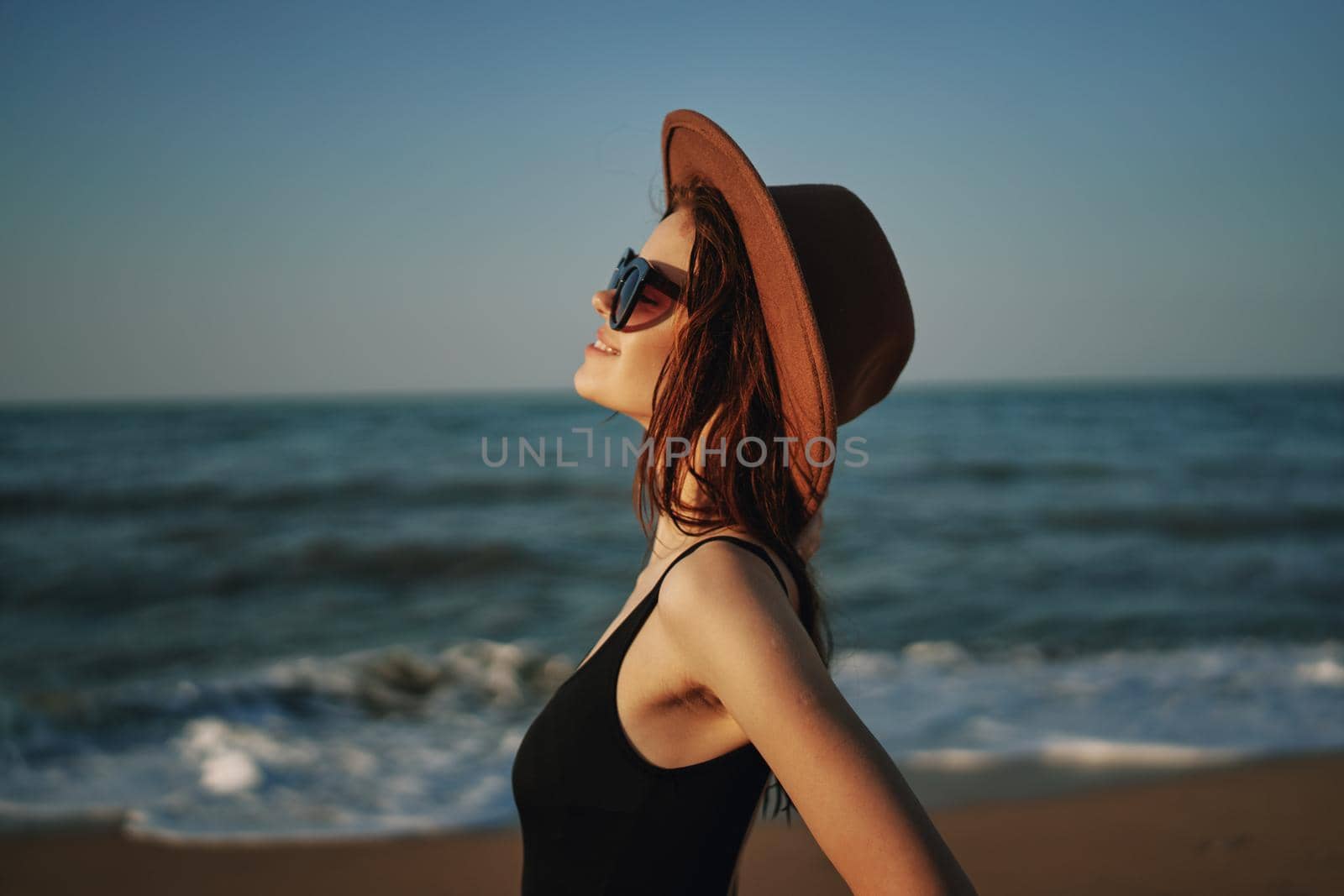pretty woman in hat walking on the beach ocean travel. High quality photo