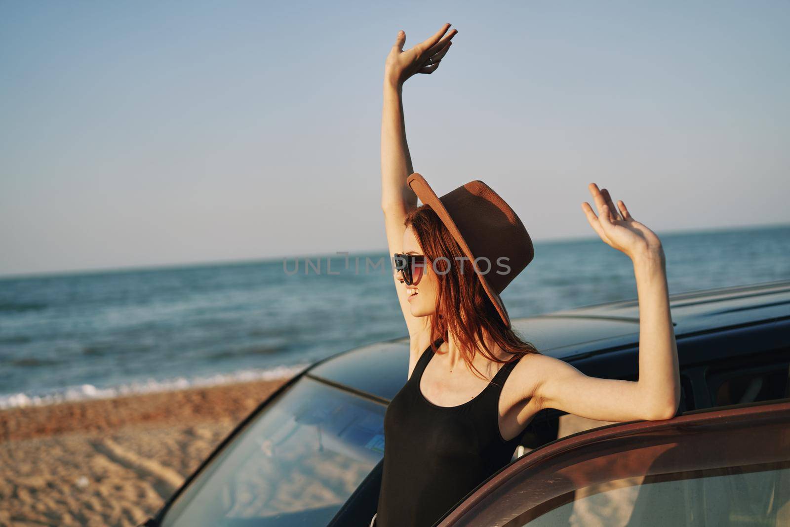 woman on the beach is with a car wearing sunglasses travel. High quality photo