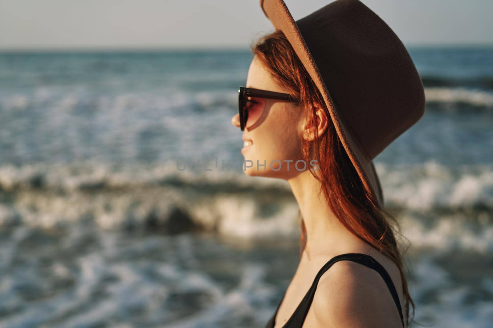 woman walking on the beach hat travel vacation sun. High quality photo