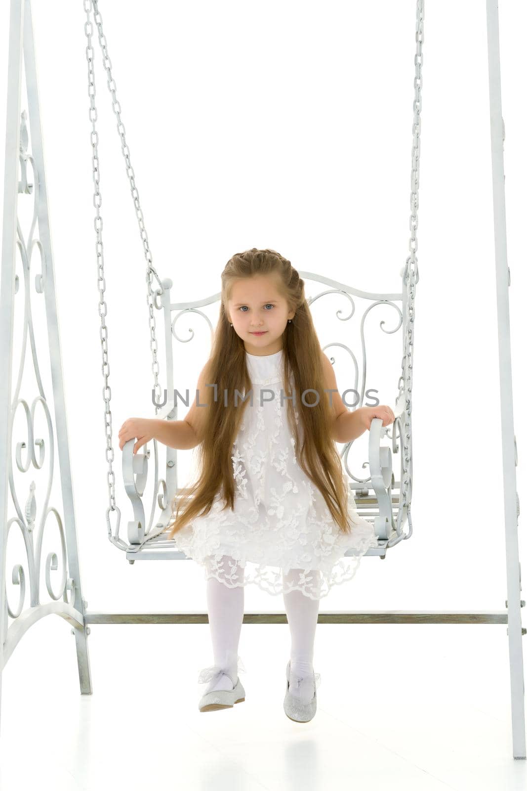 Happy little girl schoolgirl swinging on a swing. by kolesnikov_studio