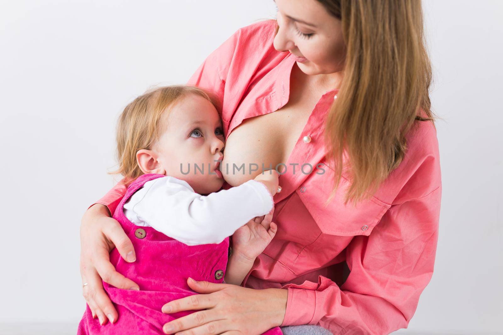 Young beautiful mother, breastfeeding her baby girl. Mom breastfeeding infant, close-up. by Satura86