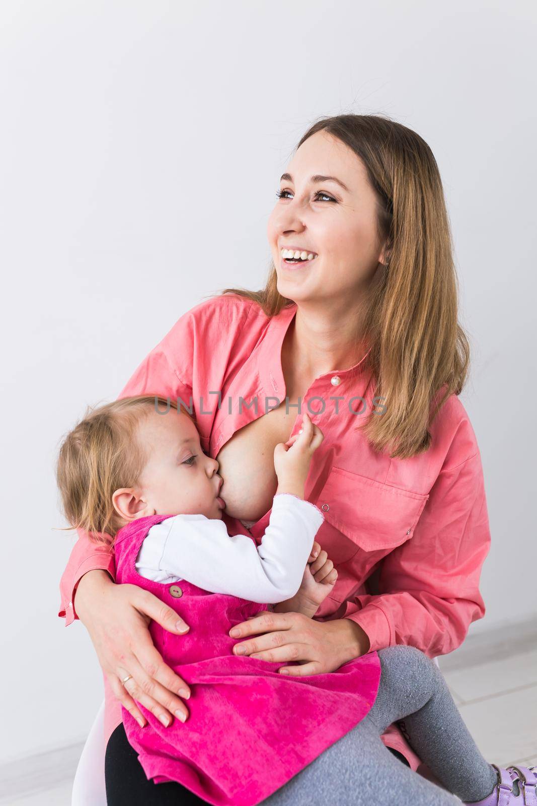 Young beautiful mother, breastfeeding her baby girl. Mom breastfeeding infant.