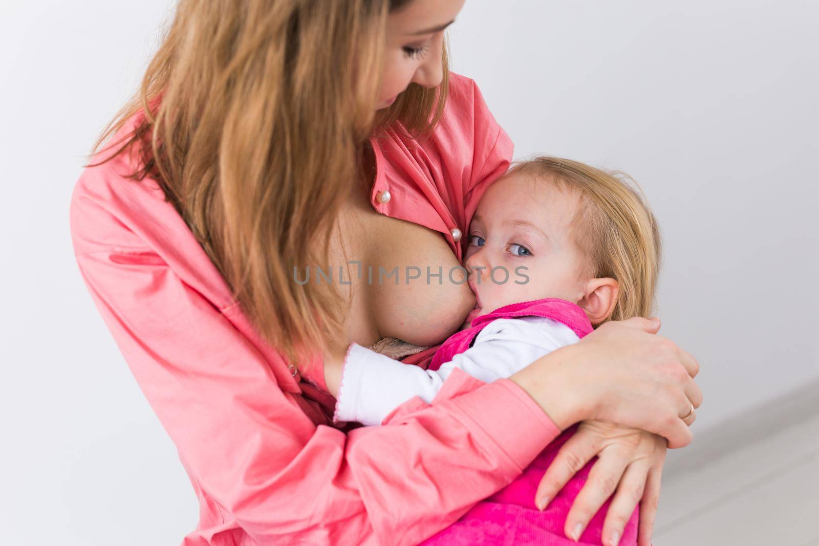 Young beautiful mother, breastfeeding her baby girl. Mom breastfeeding infant, close-up. by Satura86