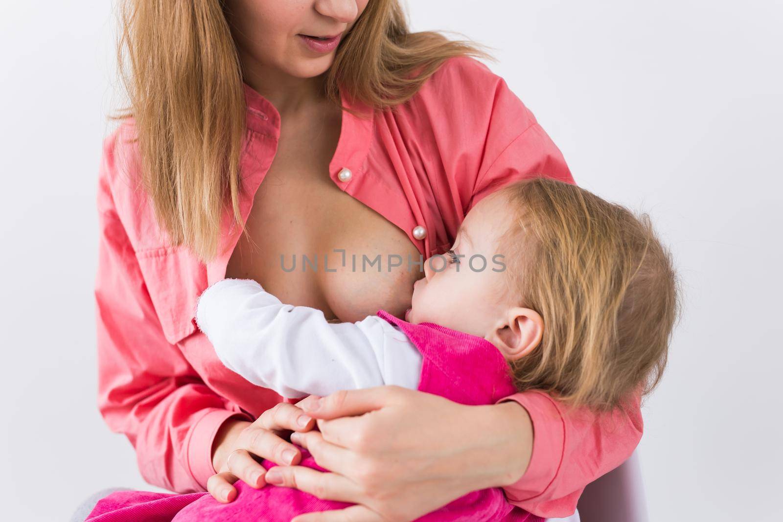 Mother breastfeeding baby in her arms at home. Young woman nursing and feeding baby. Concept of lactation infant.