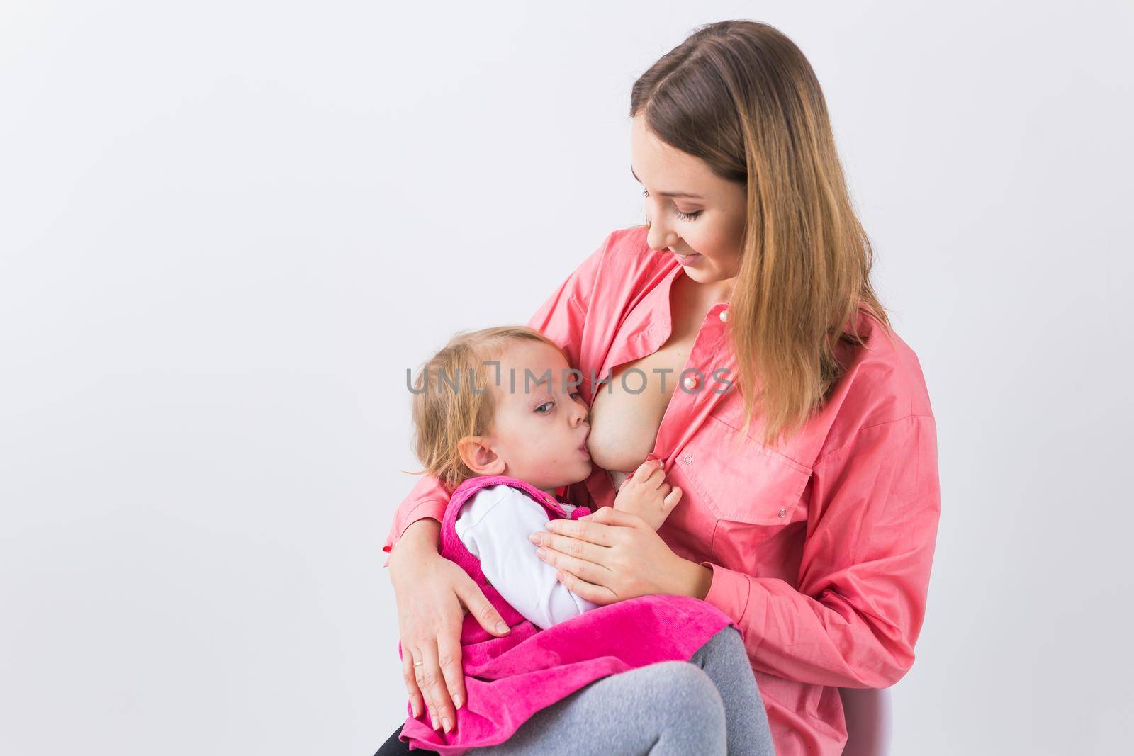 Motherhood and family concept - mother breast feeding and hugging her baby. by Satura86