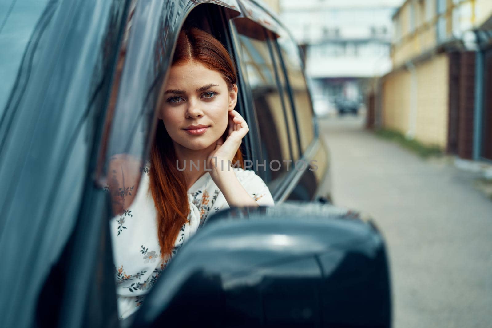 cheerful woman driving a car looks out of the window. High quality photo