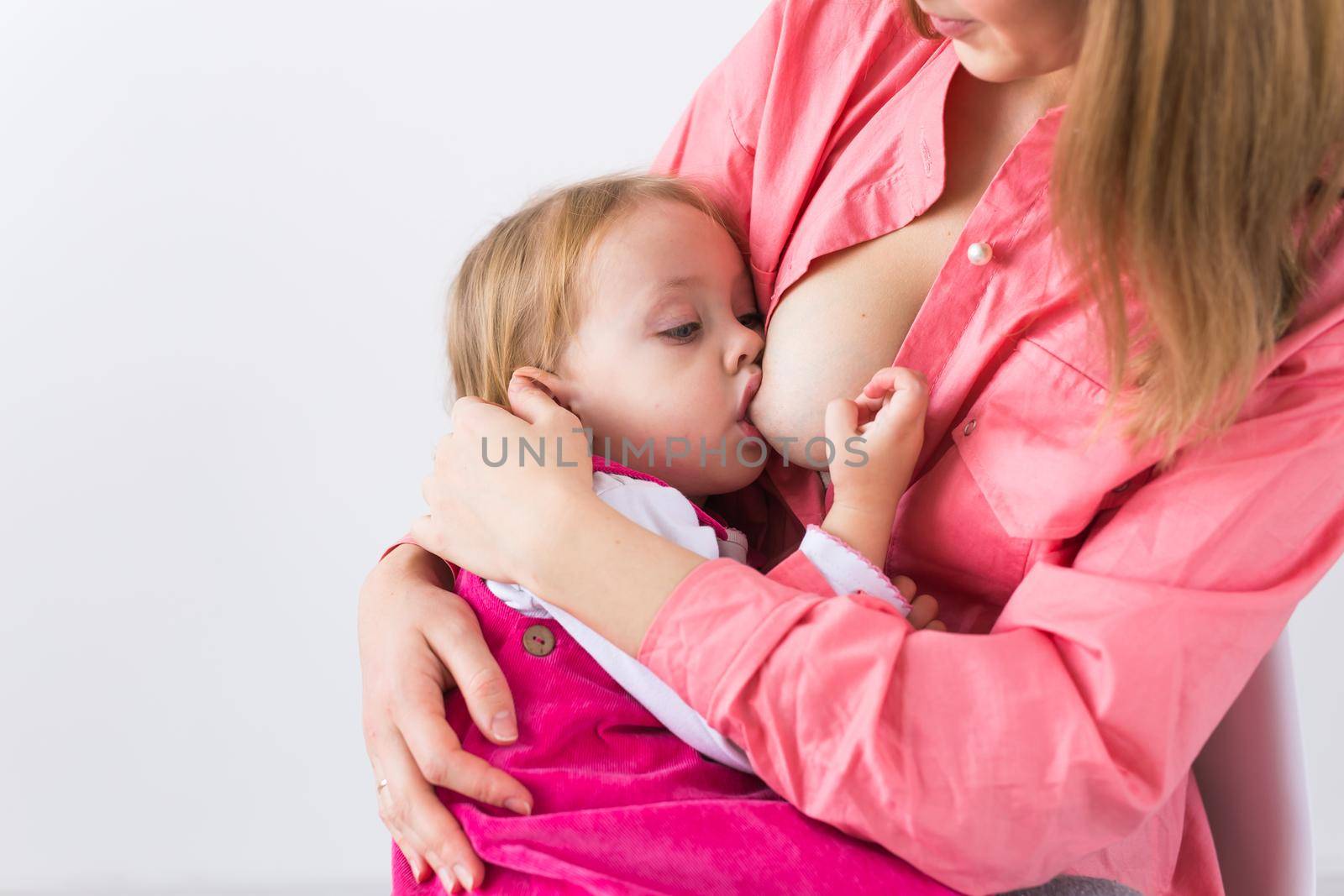 Motherhood and children concept - Mother and baby lactation on white background, close-up. by Satura86