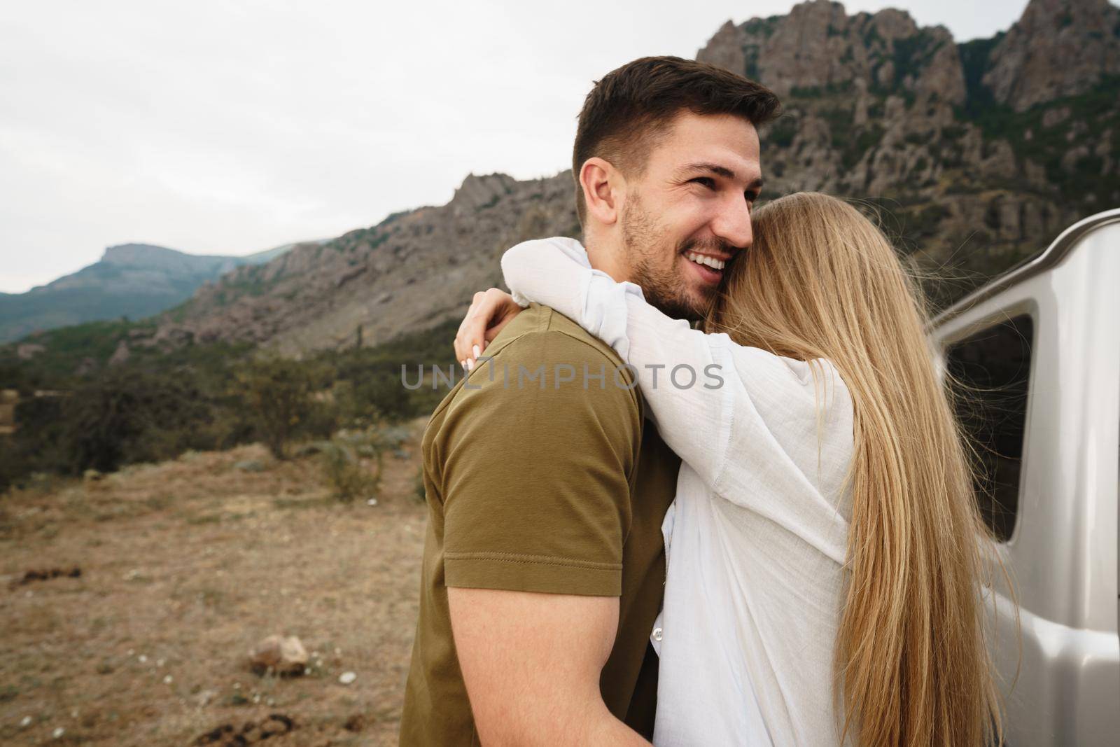 Happy loving couple hiking and hugging in mountains, close up