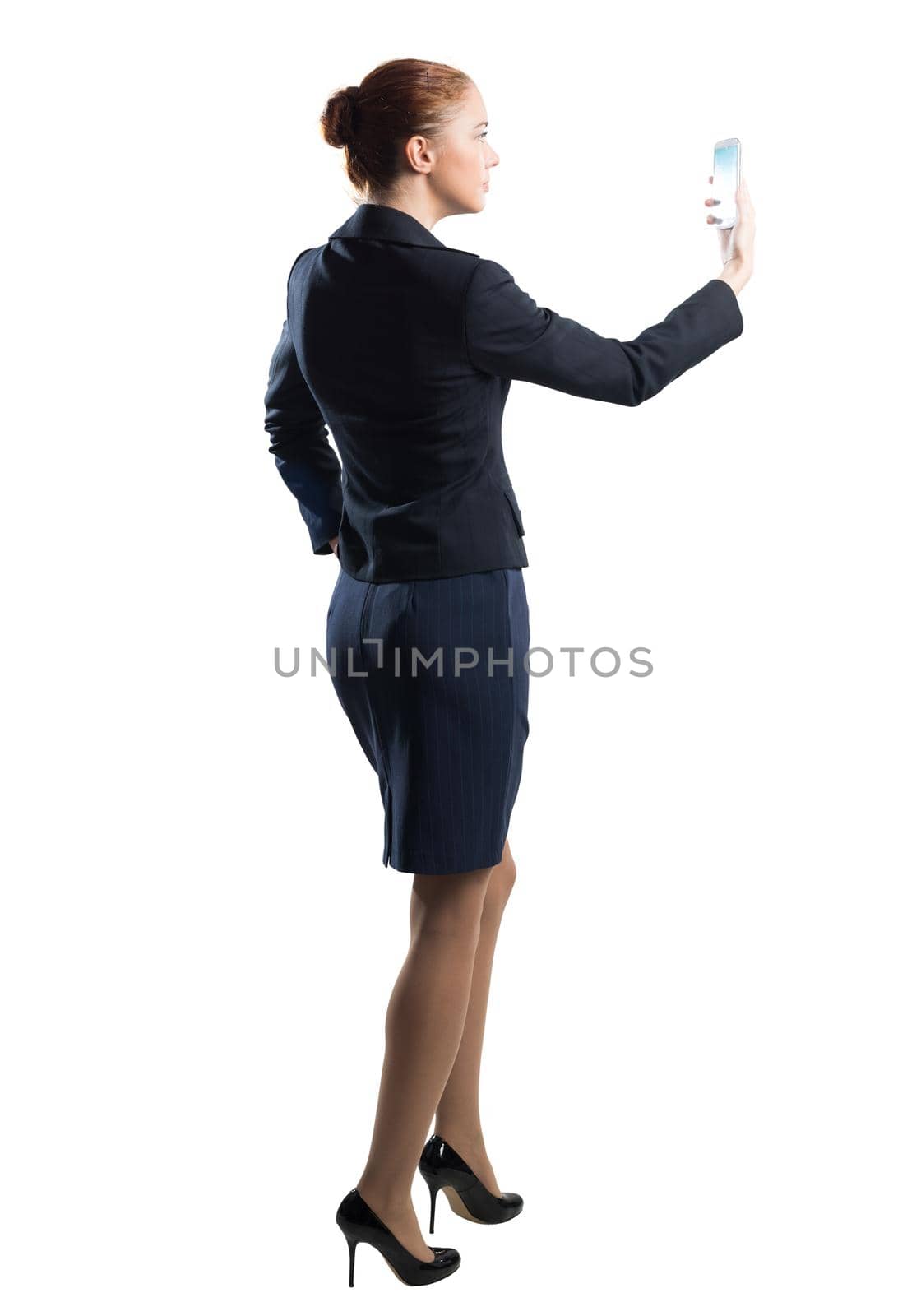 Young beautiful woman taking selfie photo with smartphone. Confident and stylish businesswoman in dark blue suit. Corporate businessperson isolated on white background. Mobile communication layout.