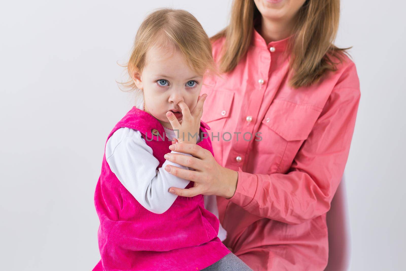 little girl pick in finger in the nose.