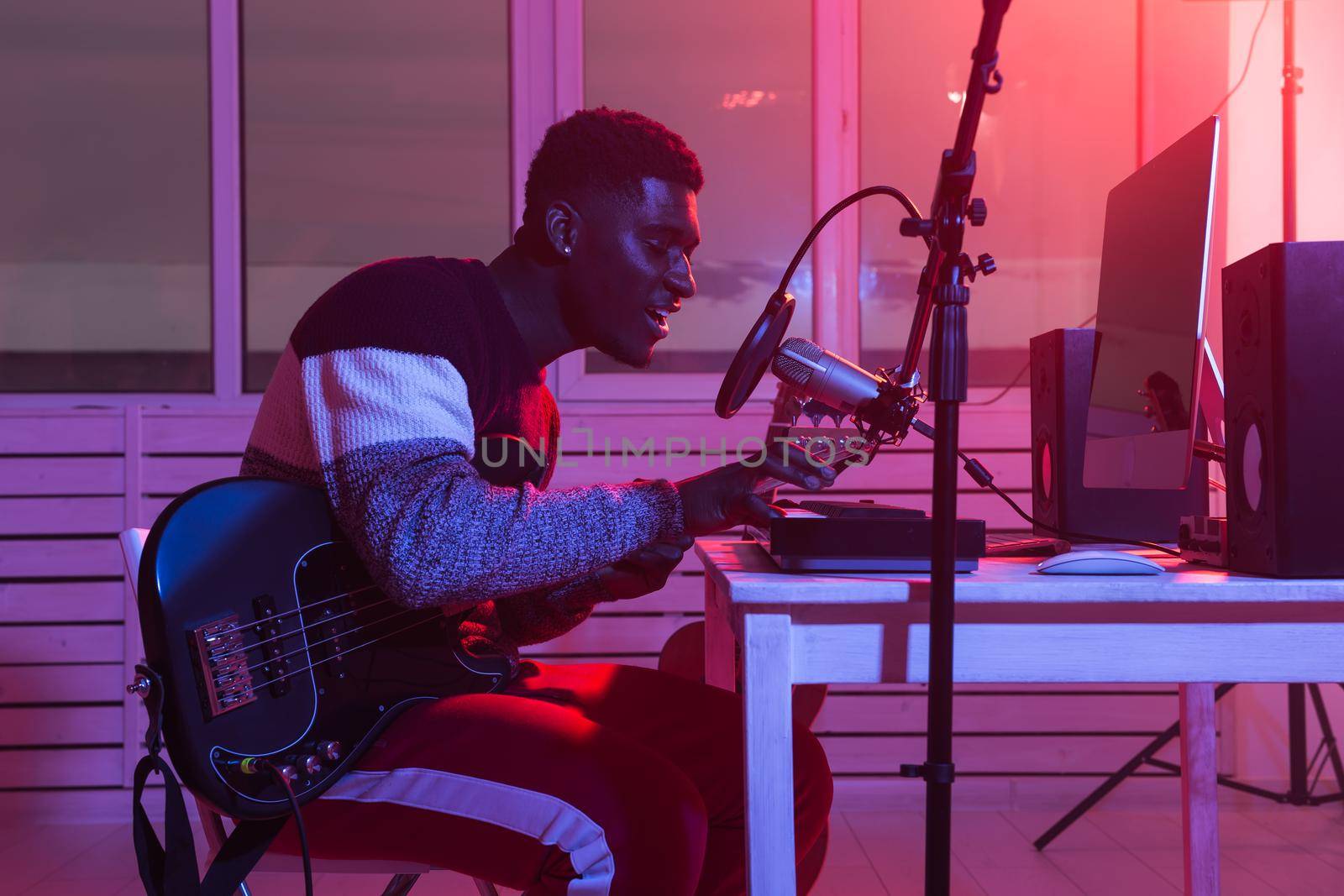 Create music and a recording studio concept - Bearded man guitarist recording electric guitar track in home studio.