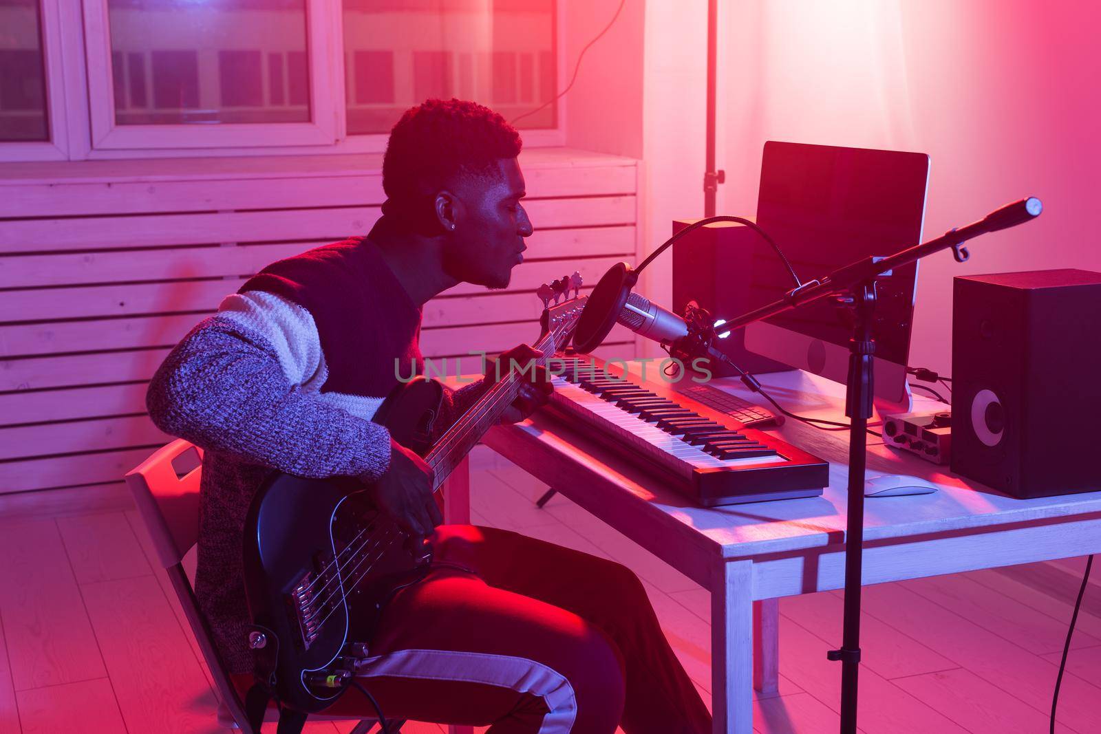 Create music and a recording studio concept - Bearded man guitarist recording electric guitar track in home studio.