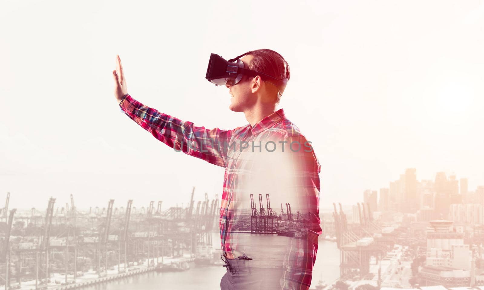 Young man with virtual reality headset or 3d glasses over cityscape background